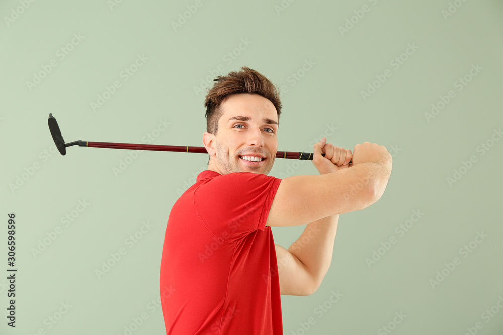 Handsome male golfer on color background