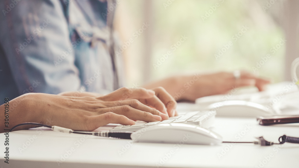 Close up shot of businesswoman hand typing and working on desktop computer on the office desk. Busin