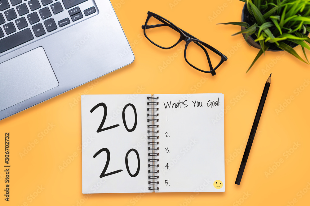 New Year Resolution Goal List 2020 - Business office desk with notebook written in handwriting about