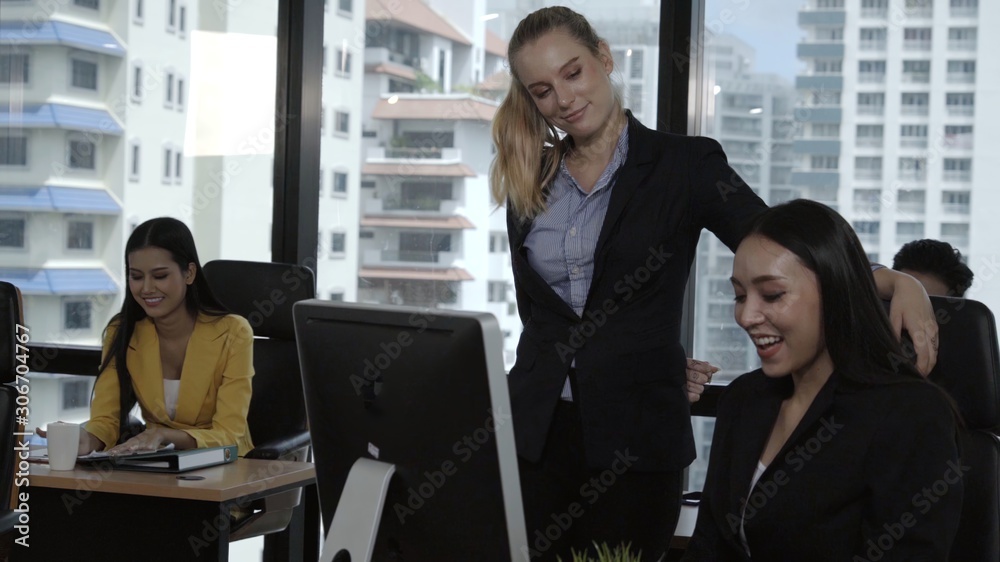 Young leader gives advice to young woman worker in modern office. Leadership and training concept.