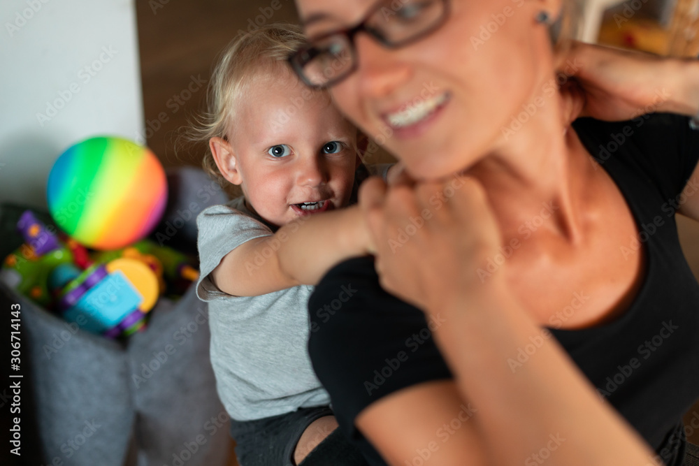 Happy mom and her little child boy playing together at home