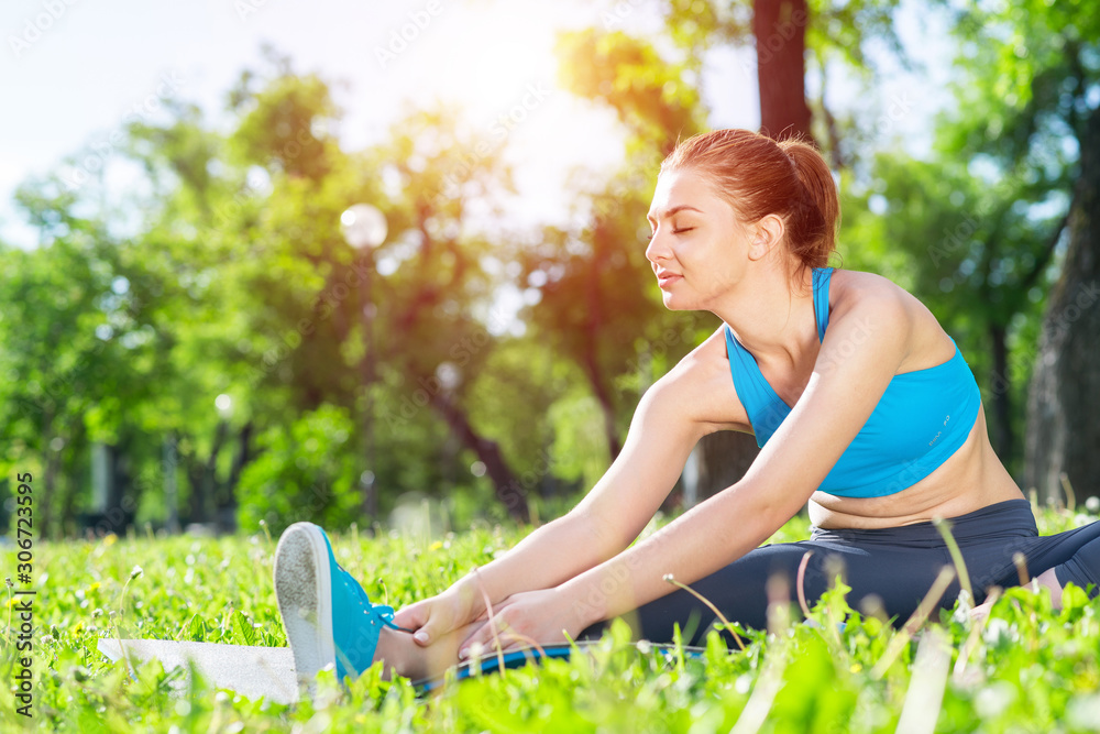 Attractive girl in sportswear doing yoga in park