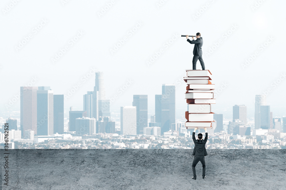 Businessman holding book pile