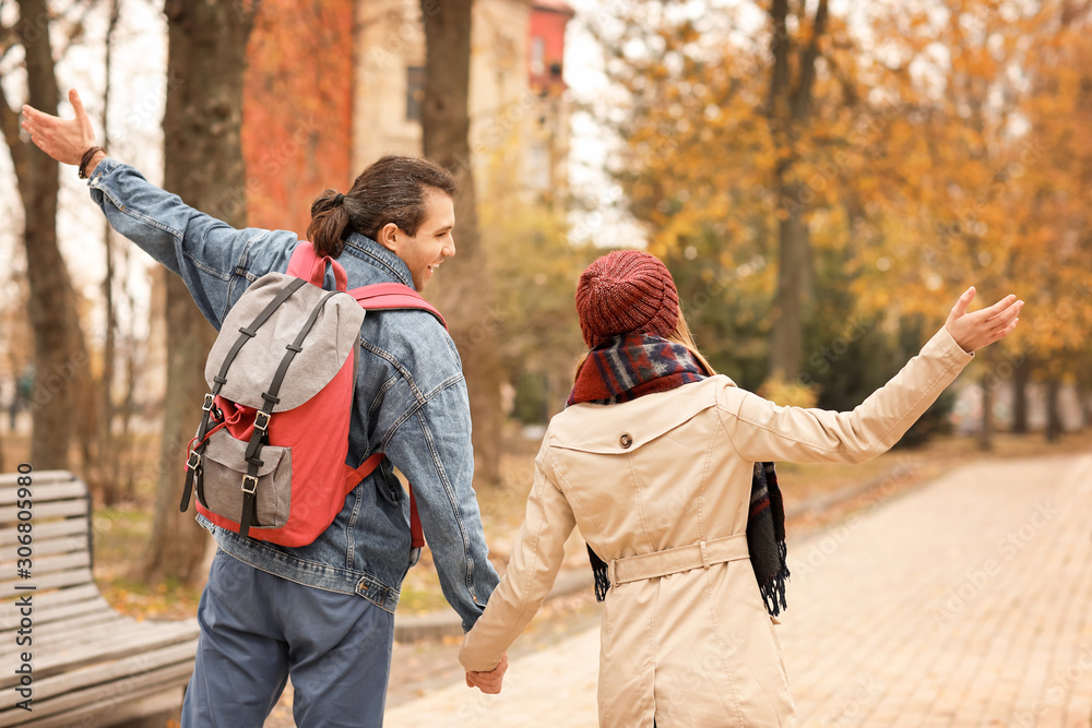 Happy couple walking in autumn park