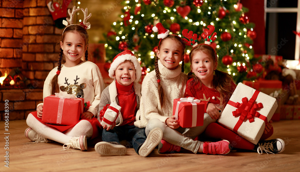 Merry Christmas! happy children with    gifts  at evening home