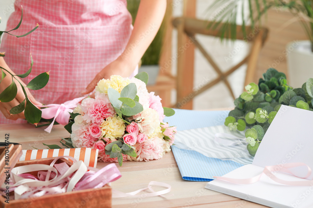 Female florist making beautiful bouquet in shop, closeup