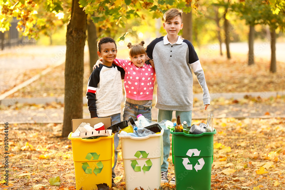 Little children collecting trash outdoors. Concept of recycling