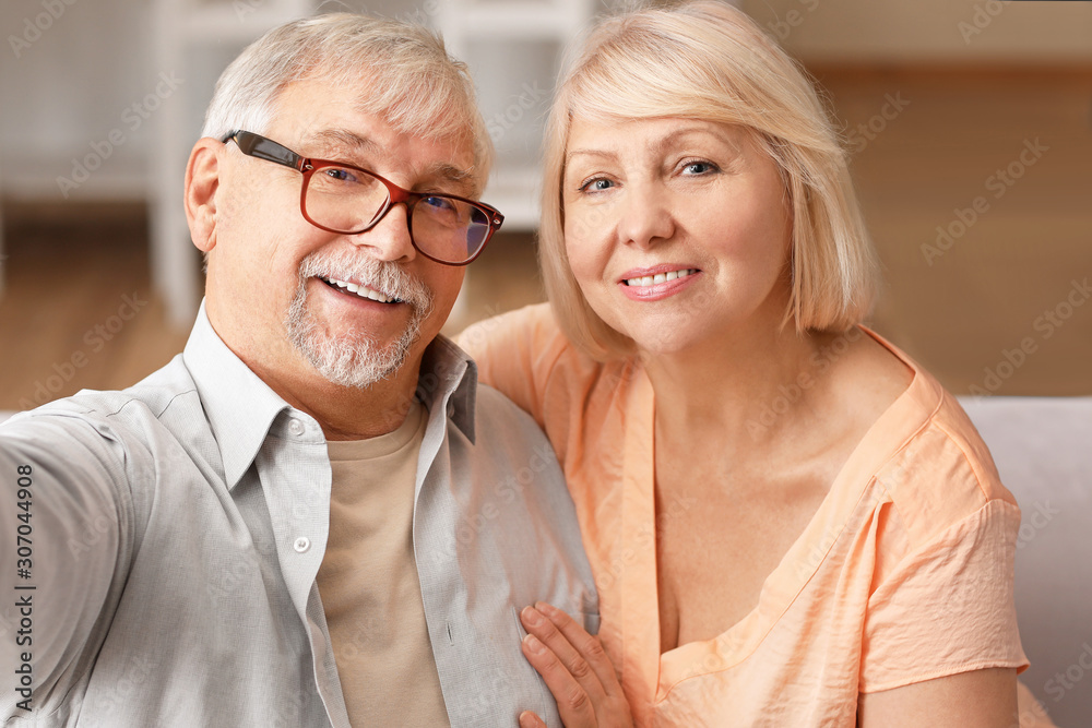 Mature couple taking selfie together at home