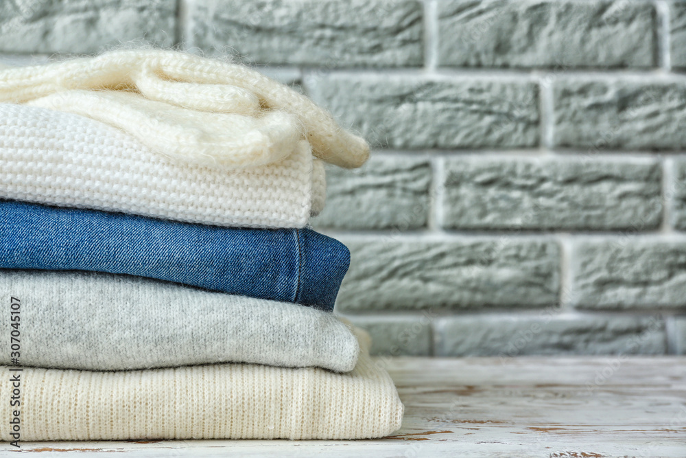 Set of warm winter clothes on table