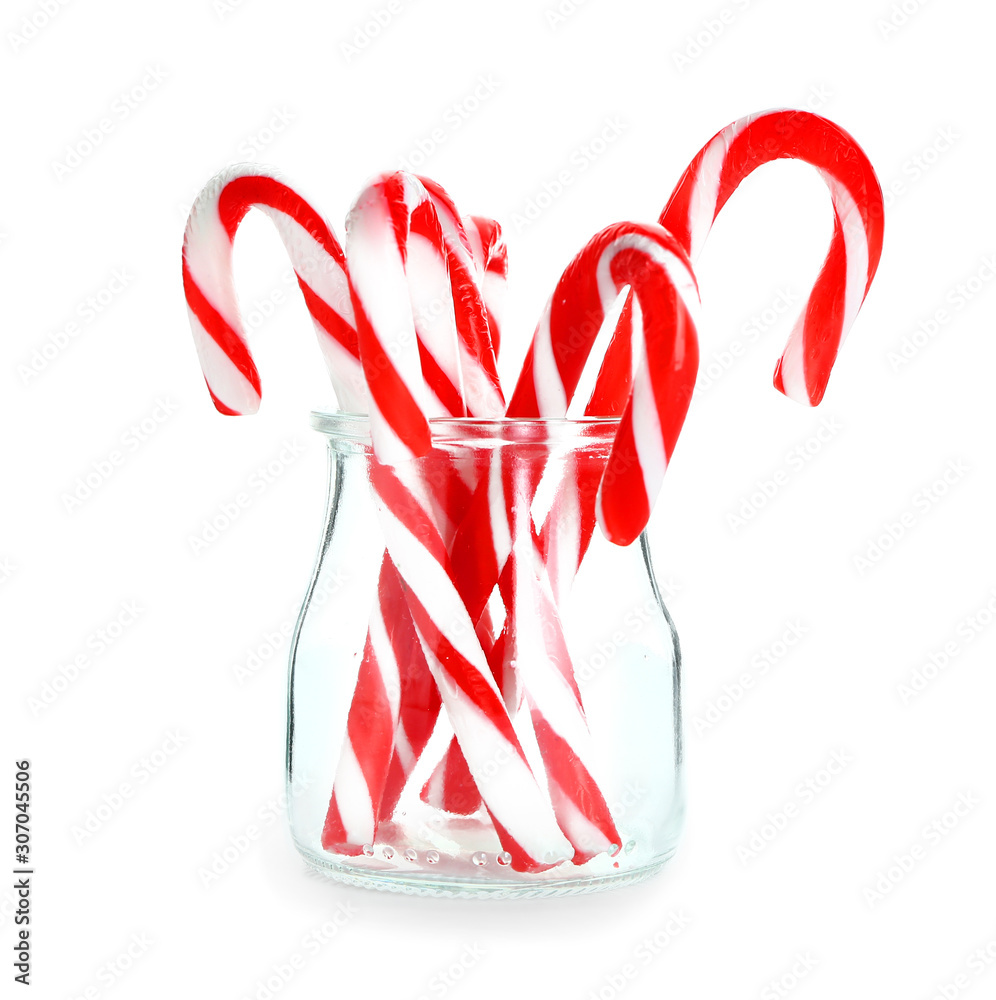 Glass jar with Christmas candy canes on white background