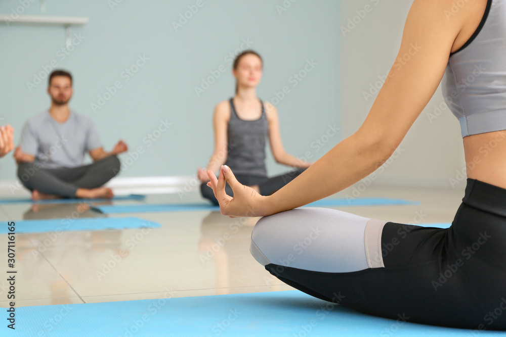 Group of people practicing yoga in gym