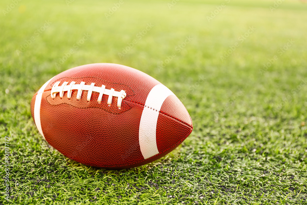 Rugby ball on green field outdoors