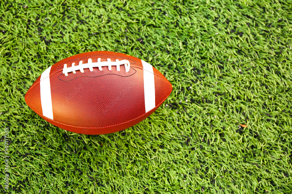 Rugby ball on green field outdoors