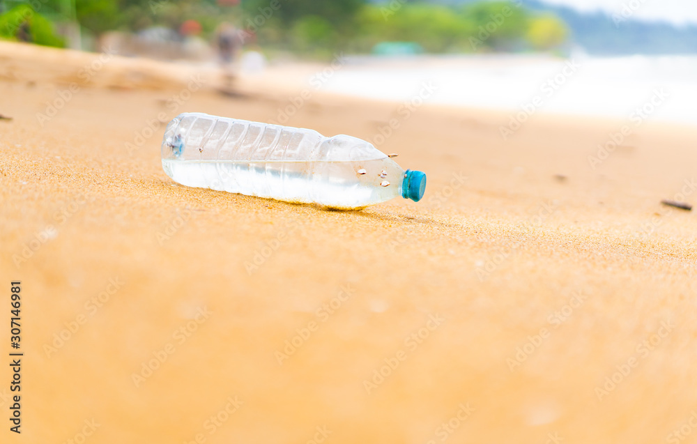 Plastic trash bottle with shell at the sand beach.Single use plastic is a human addiction that is de