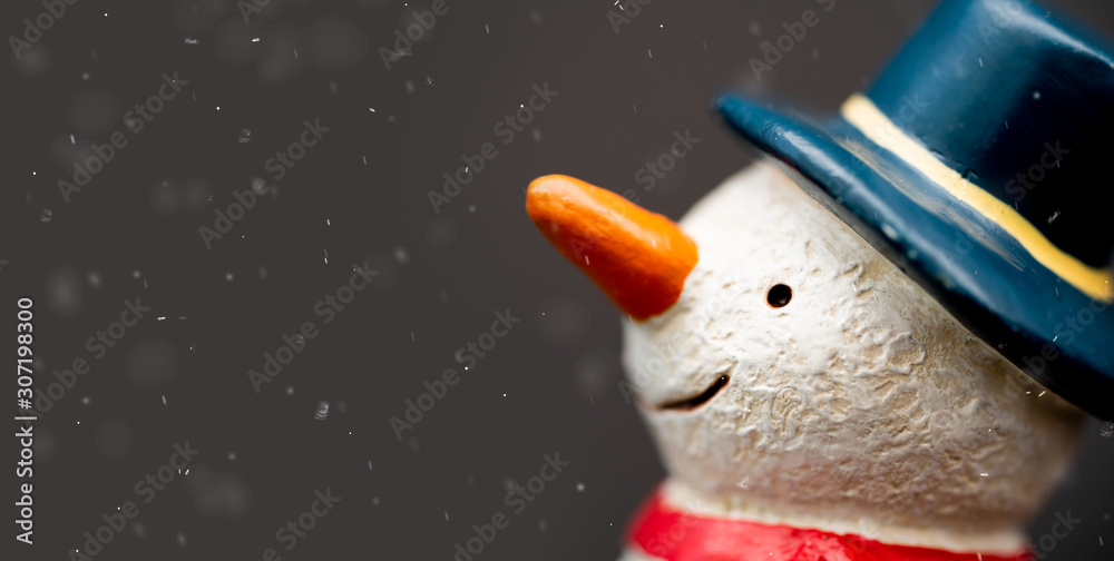 Happy smiley snowman wear blue hat and carrot nose standing with snowflakes in winter christmas seas