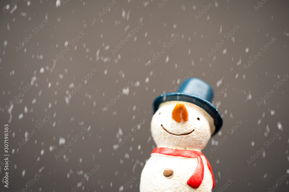 Happy smiley snowman wear blue hat and carrot nose standing with snowflakes in winter christmas seas