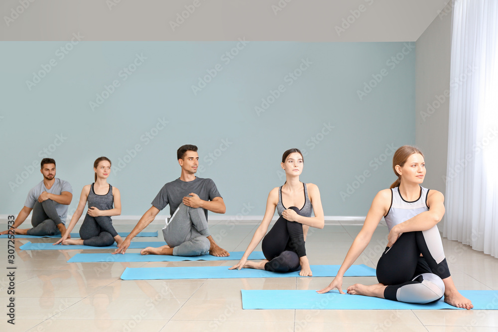 Group of people practicing yoga in gym