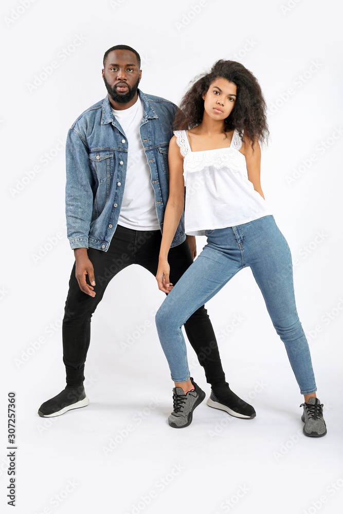 Portrait of stylish young African-American couple on white background