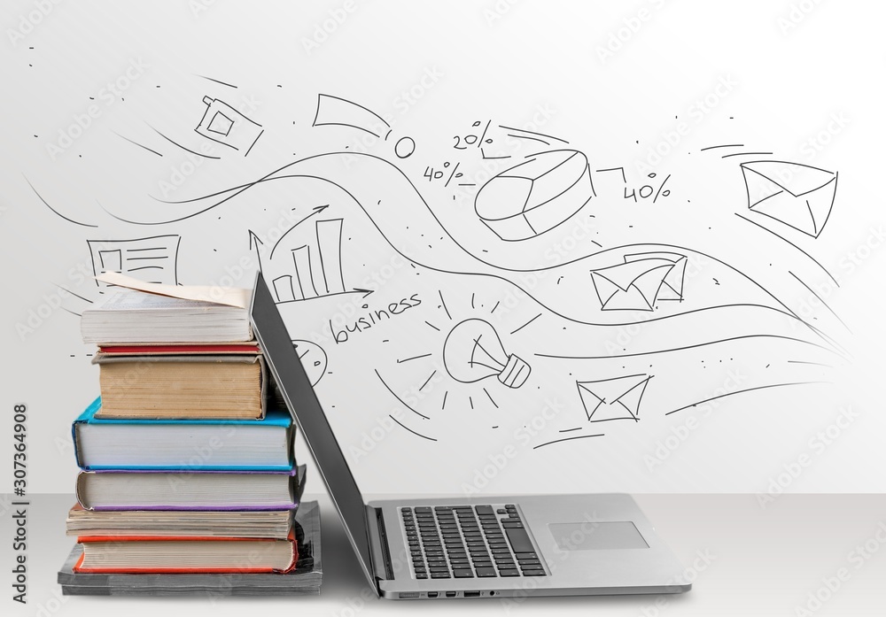 Stack of books with laptop on wooden table