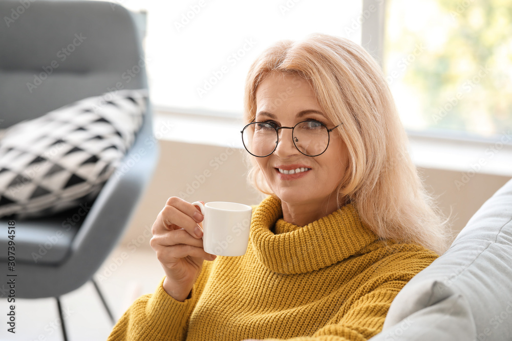 Beautiful mature woman drinking coffee at home