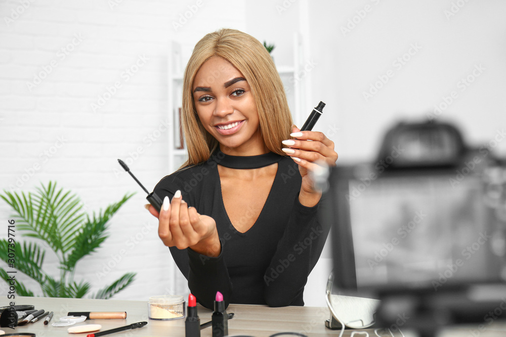 Young African-American beauty blogger recording video at home