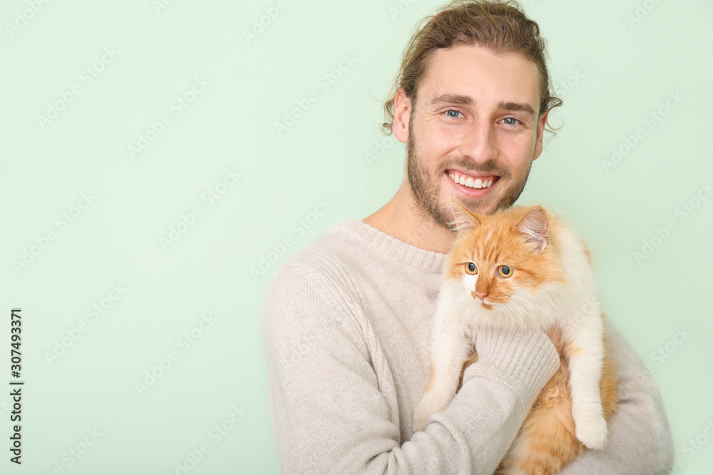 Man with cute cat on color background