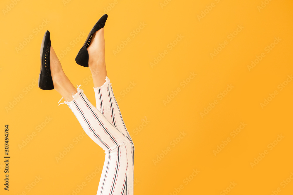 Young woman in stylish shoes on color background