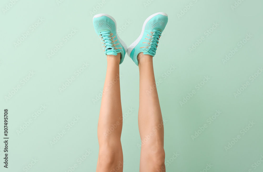 Young woman in stylish shoes on color background