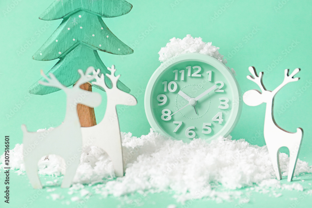 Clock, snow, figure of fir tree and deer on color background. Christmas countdown concept