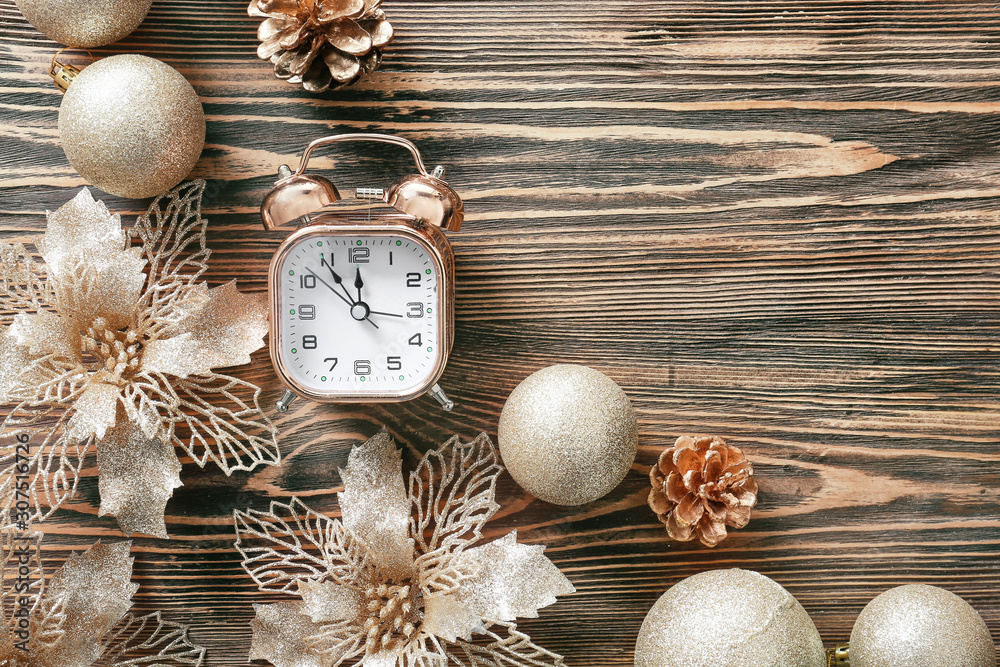 Alarm clock and decor on wooden background. Christmas countdown concept