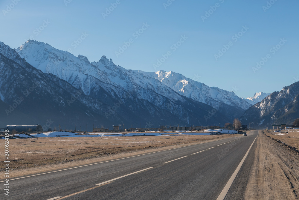 通往山区的笔直道路。山区的美丽自然。旅行和徒步旅行。