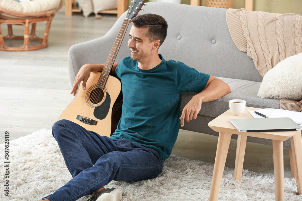 Handsome man with guitar at home