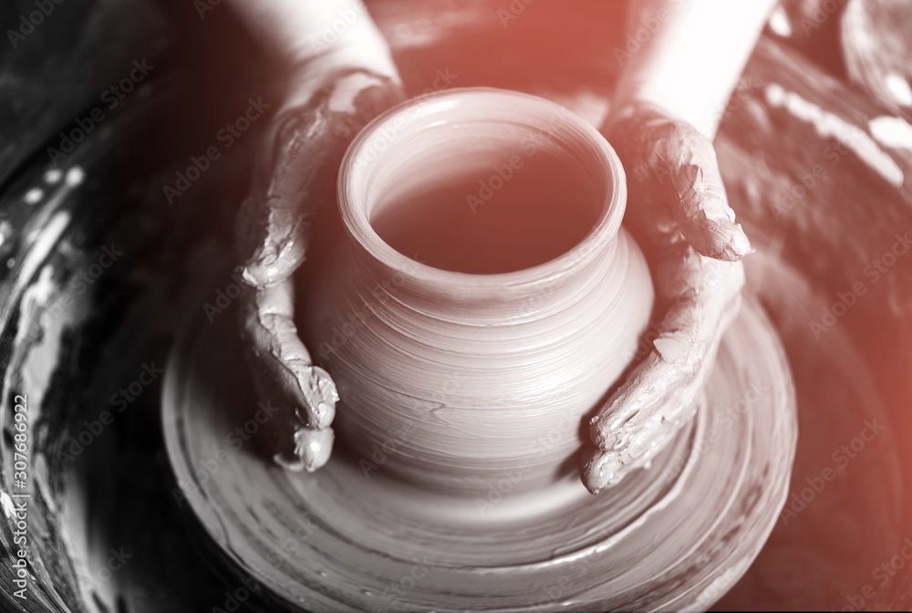 Hand of potter doing  clay pot on background