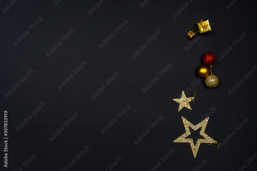 Christmas ornaments (Christmas baubles, stars and little presents) on black background