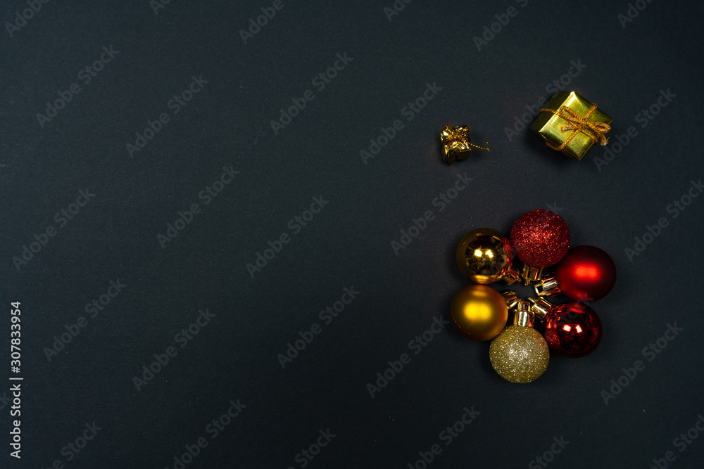 Christmas ornaments (Christmas baubles, stars and little presents) on black background