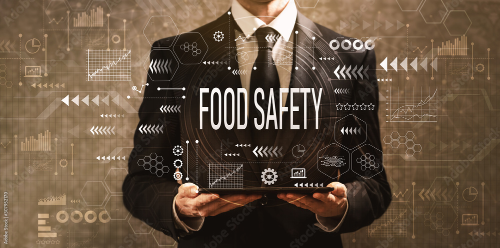 Food safety with businessman holding a tablet computer on a dark vintage background