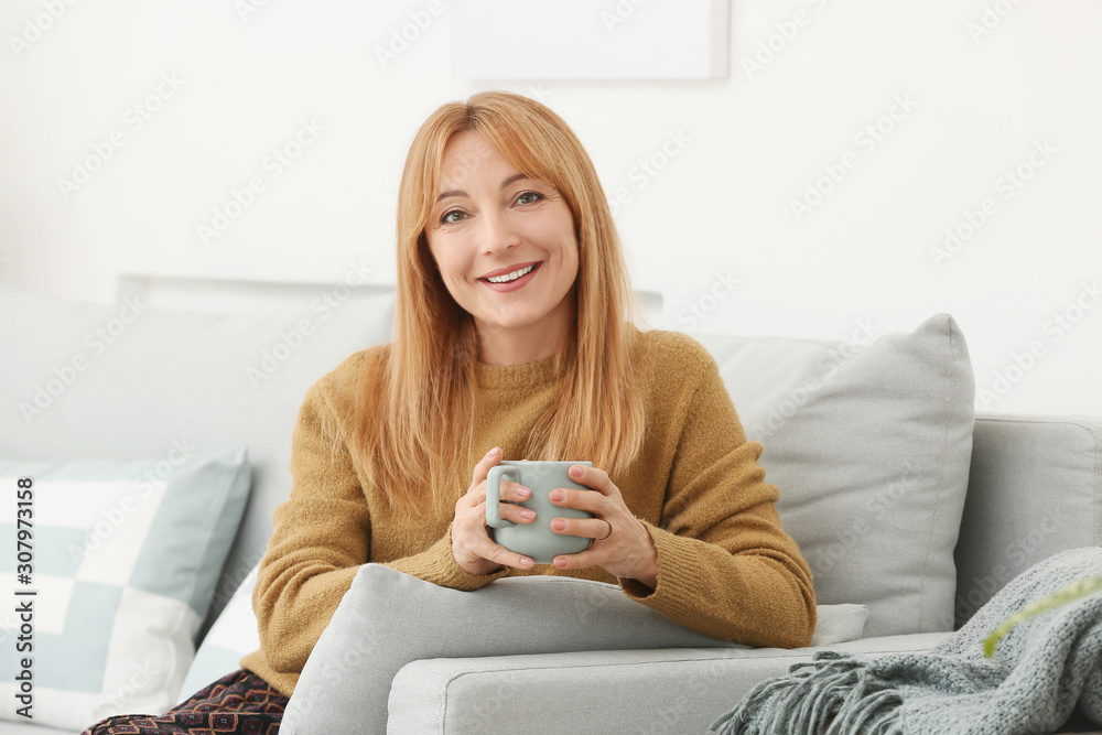 美丽的成熟女人在家喝咖啡