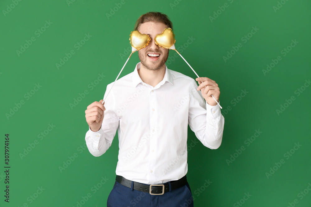 Handsome man with hearts on color background. Valentines Day celebration