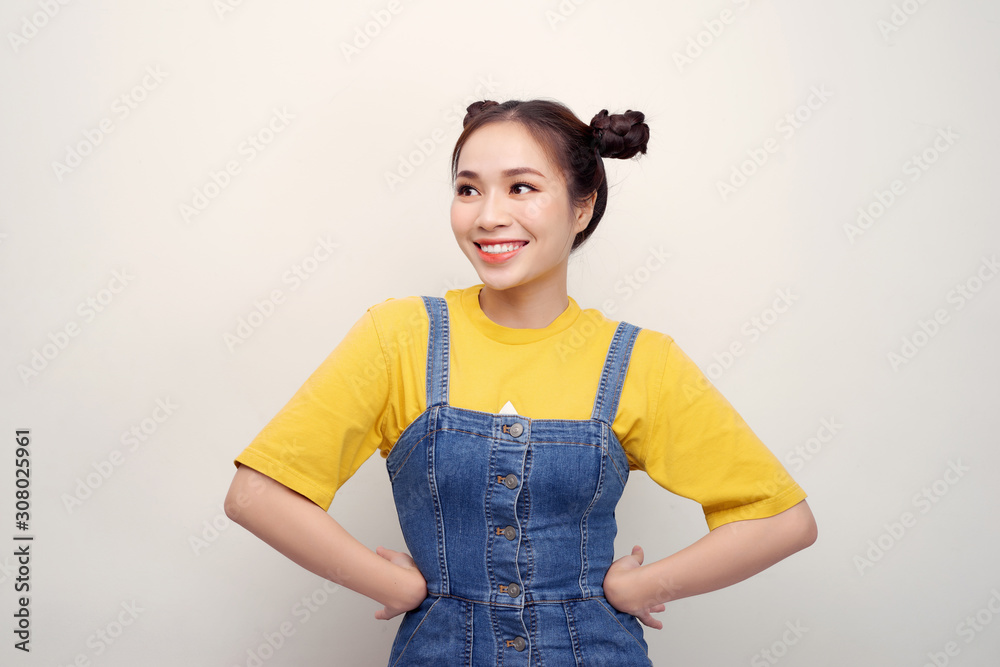 Portrait of beautiful young Asian woman with hair buns and looking flirty at camera on white backgro