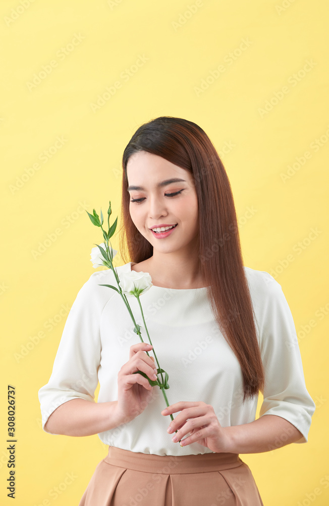 一位手持鲜花的迷人年轻女子的特写肖像