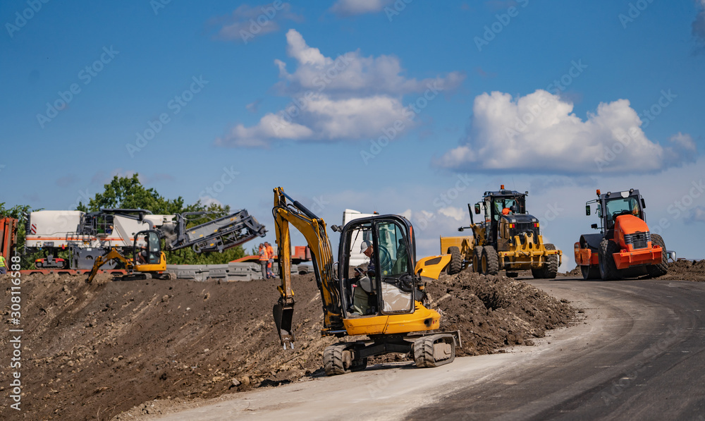 An excavator in a road construction site. Yellow special technic, machinery. Road repair concept.