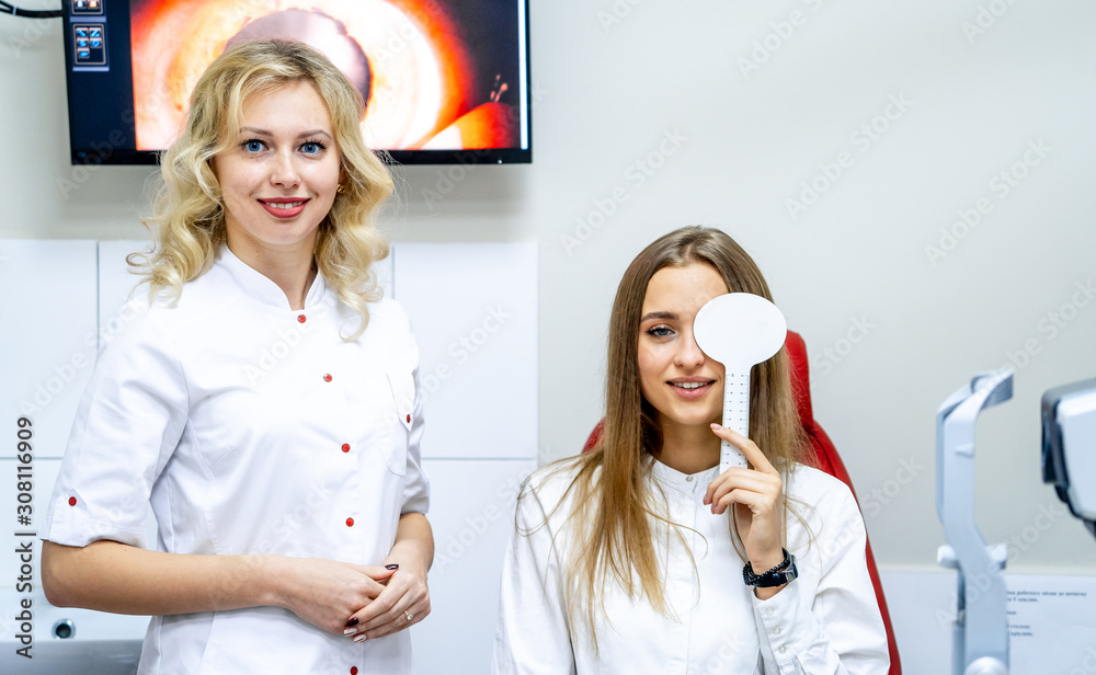 Young woman checking vision during a medical examination at the ophthalmological office. Eye health 