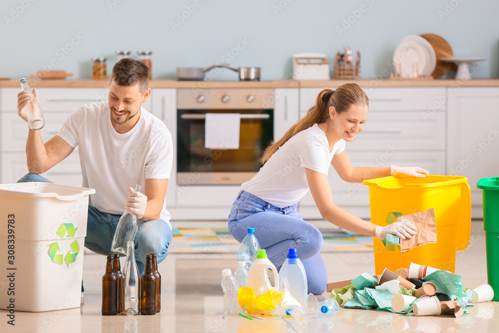 Couple sorting garbage at home. Concept of recycling