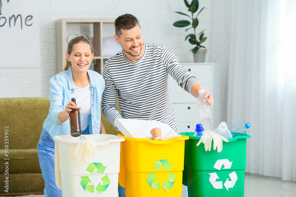 Couple sorting garbage at home. Concept of recycling