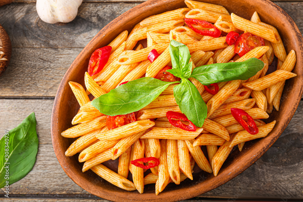 Plate with tasty pasta on wooden table