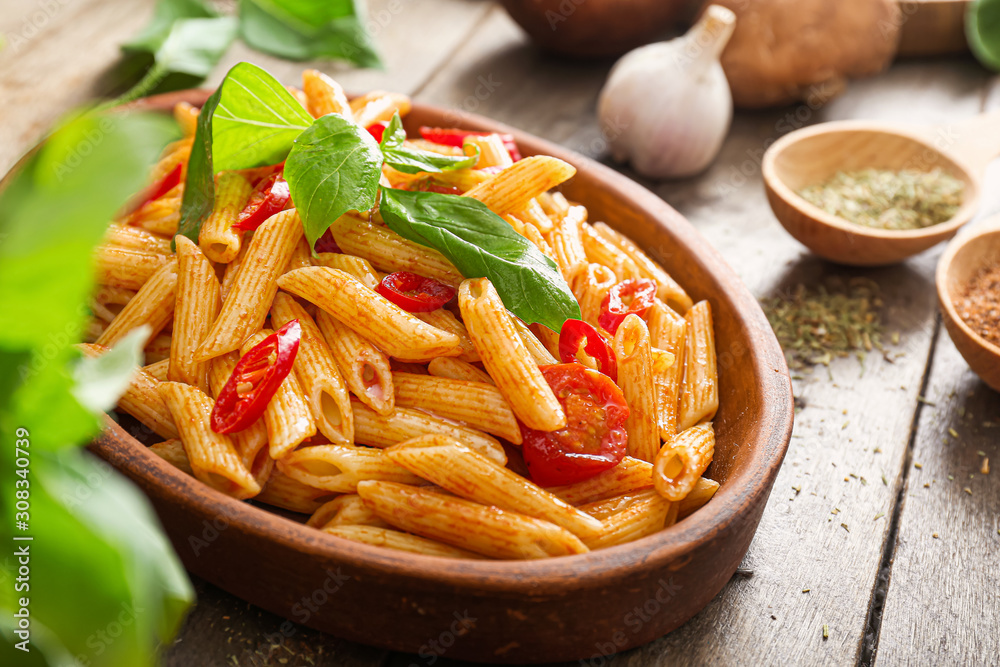 Plate with tasty pasta on wooden table