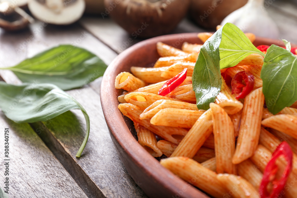 Plate with tasty pasta on wooden table