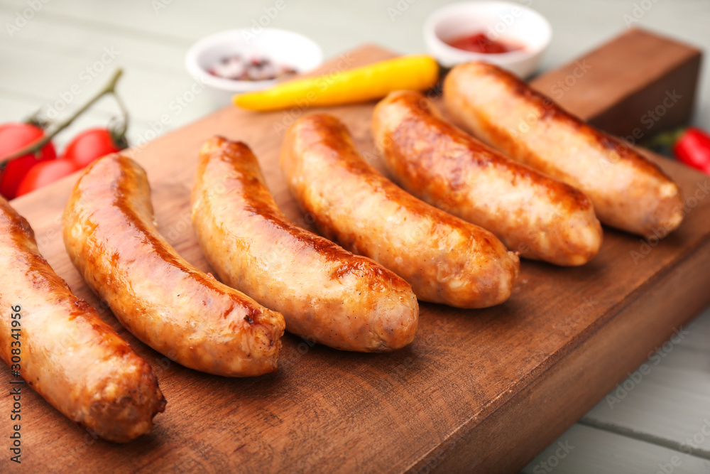 Tasty grilled sausages wooden board, closeup