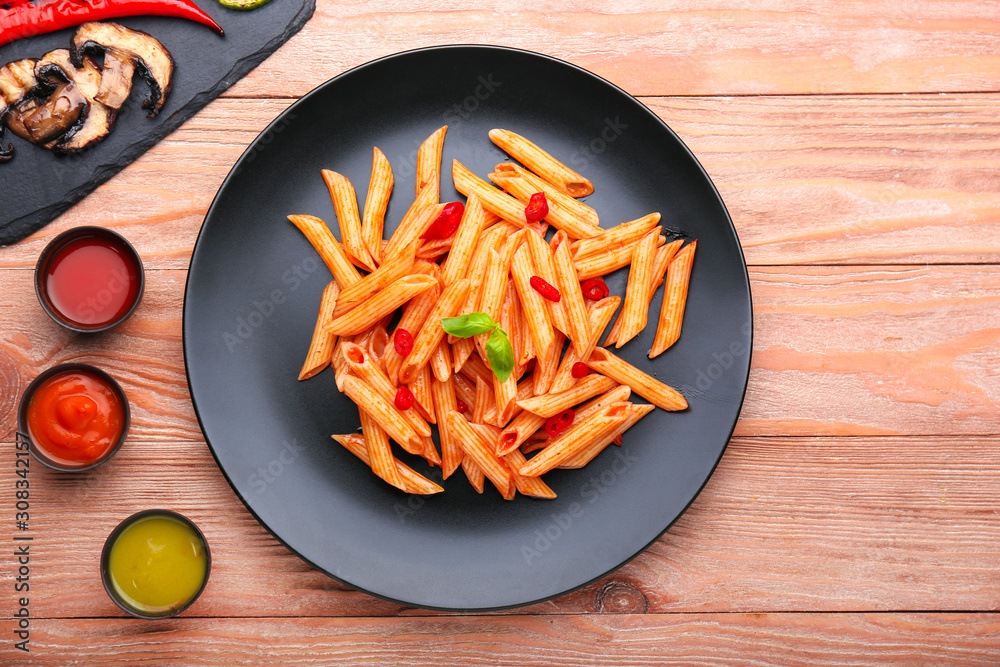 Plate with tasty pasta on wooden table