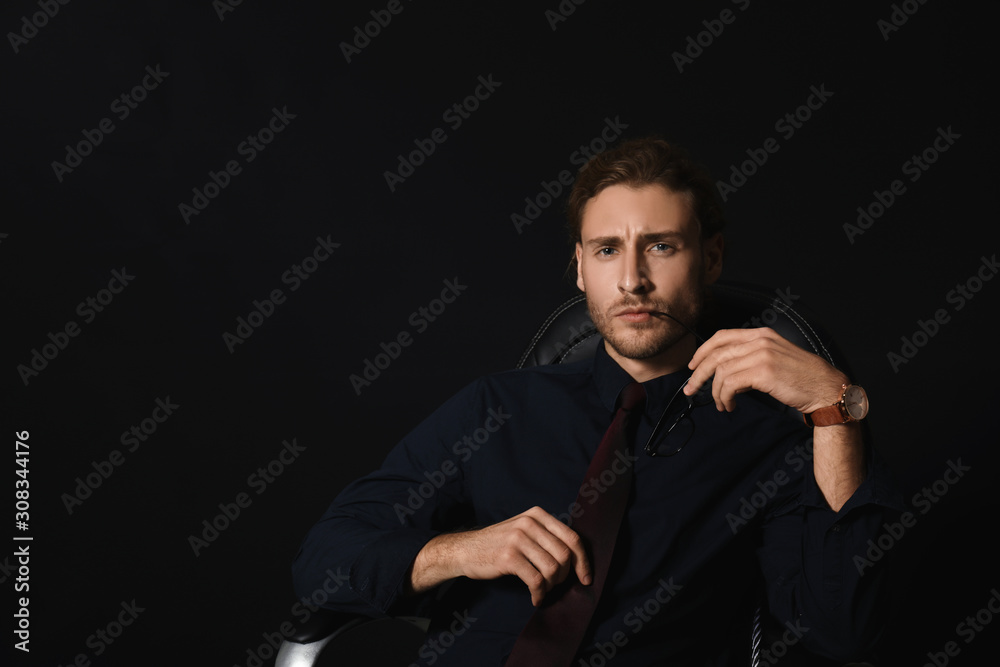 Portrait of handsome businessman on dark background